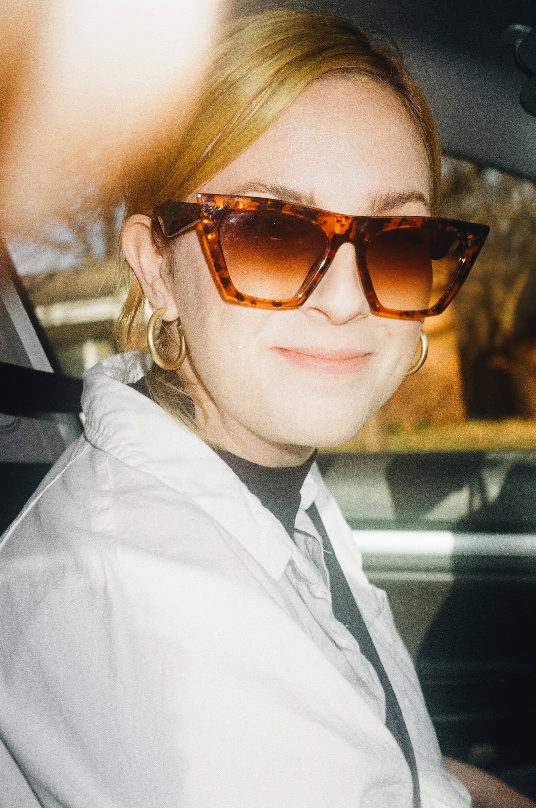 woman in white collared shirt wearing brown sunglasses