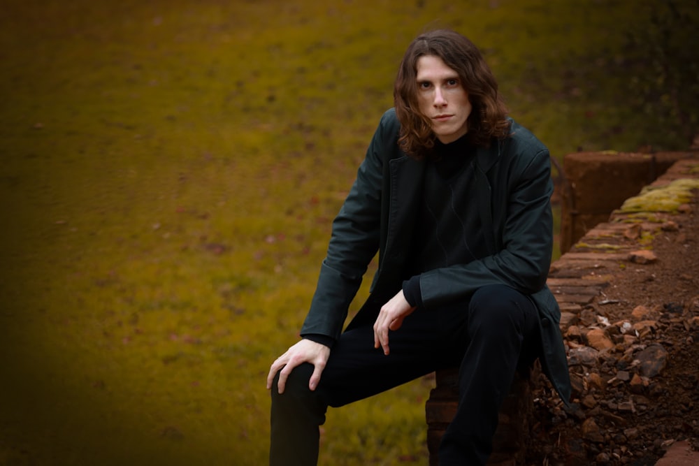 woman in black jacket sitting on brown wooden bench