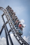 people riding on roller coaster during daytime