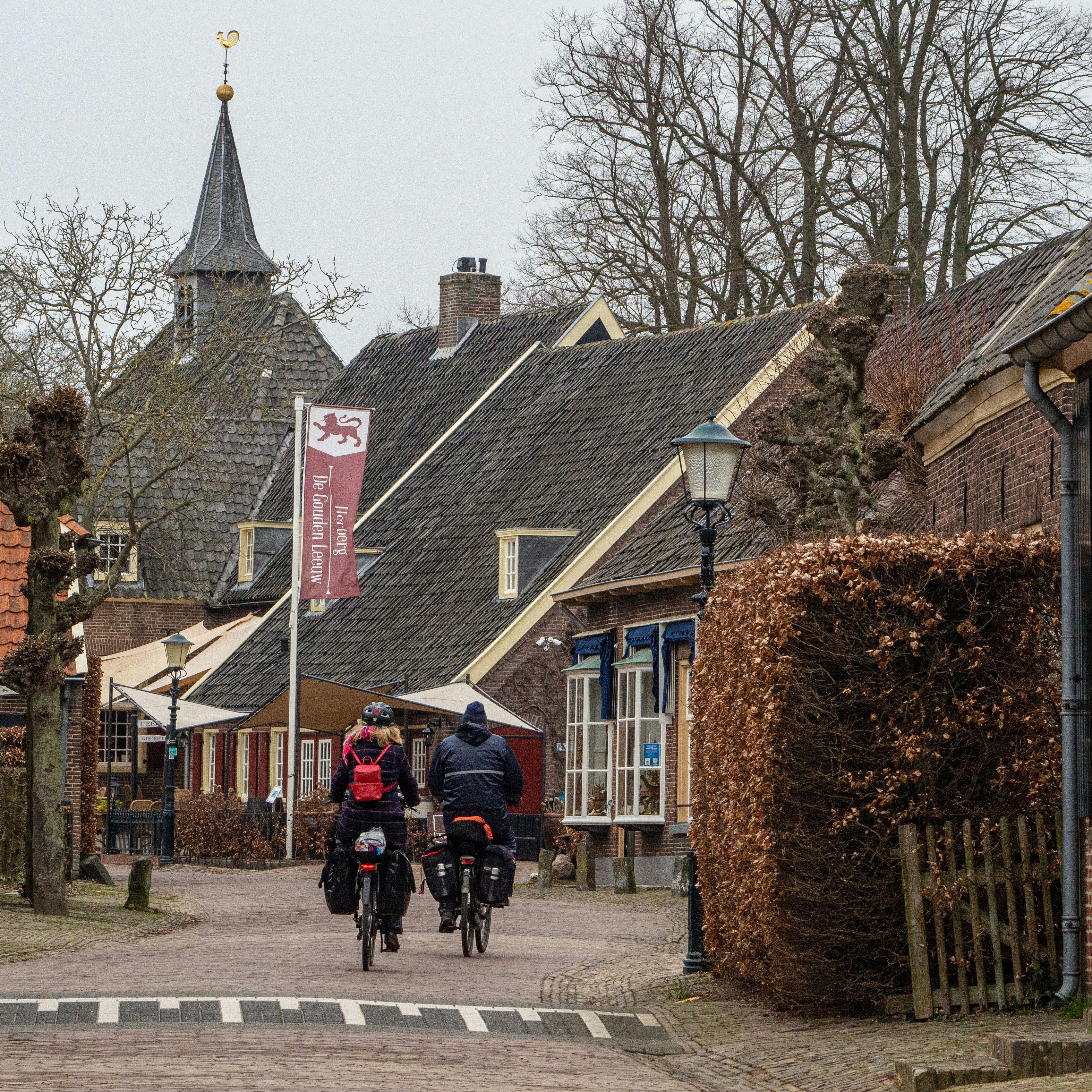 people walking on sidewalk near brown concrete building during daytime