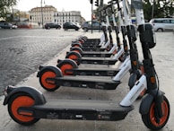 A group of electric bikes lined up against a vibrant city backdrop.