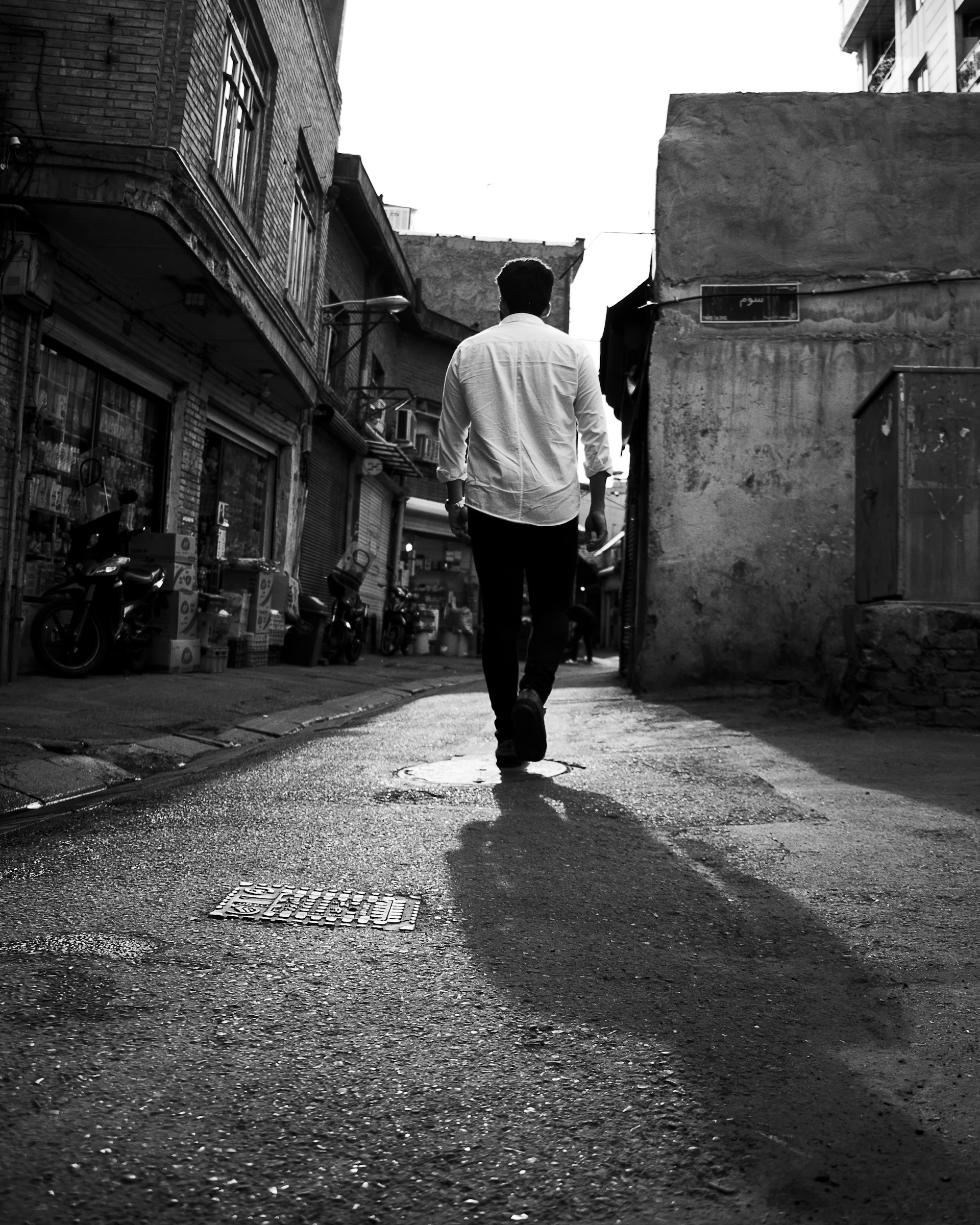 man in white shirt walking on street