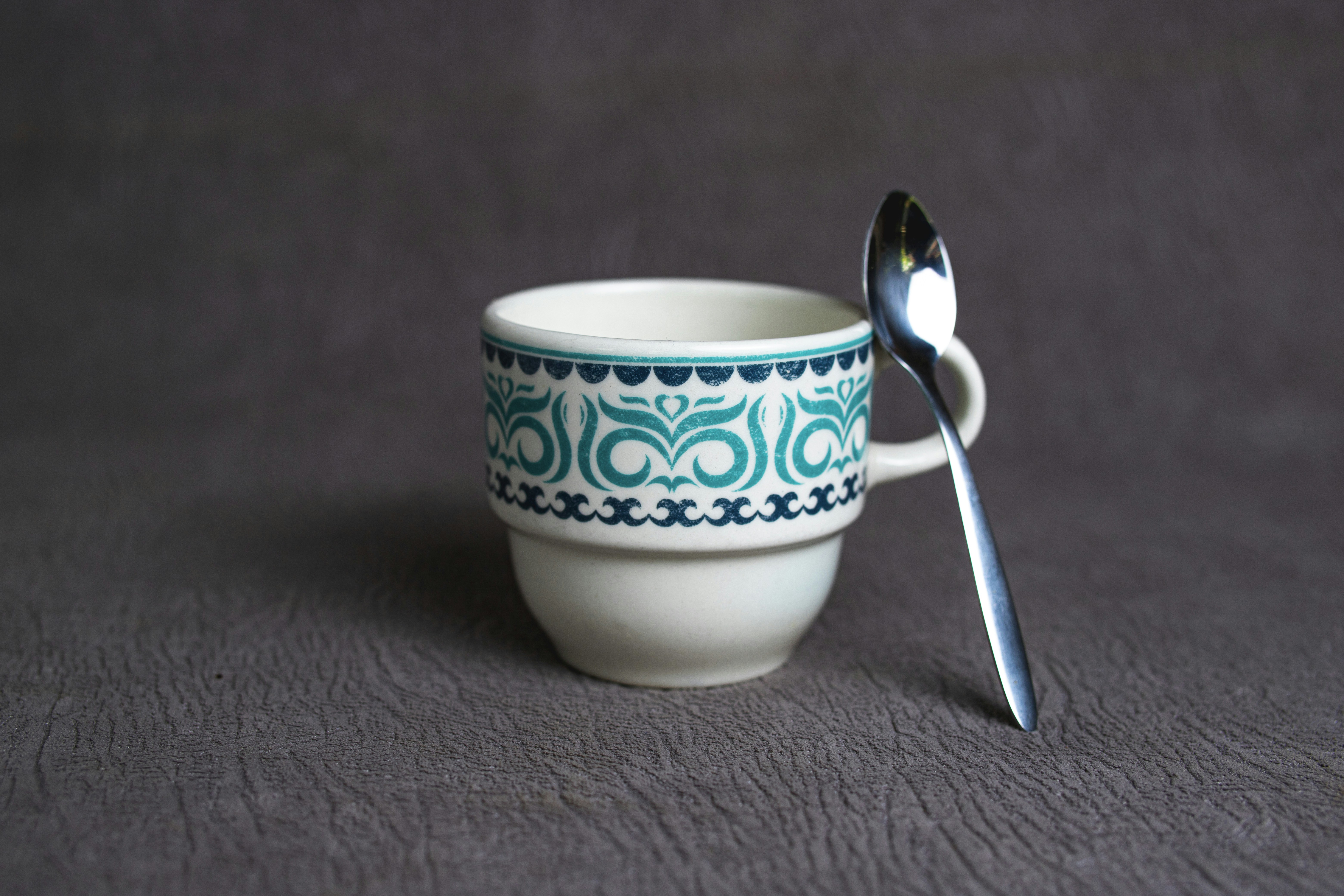 white and blue ceramic mug with spoon