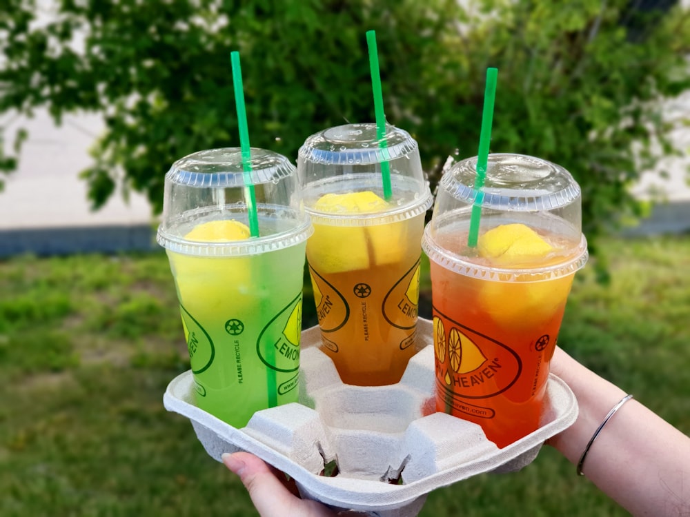 two clear plastic disposable cups with green straw