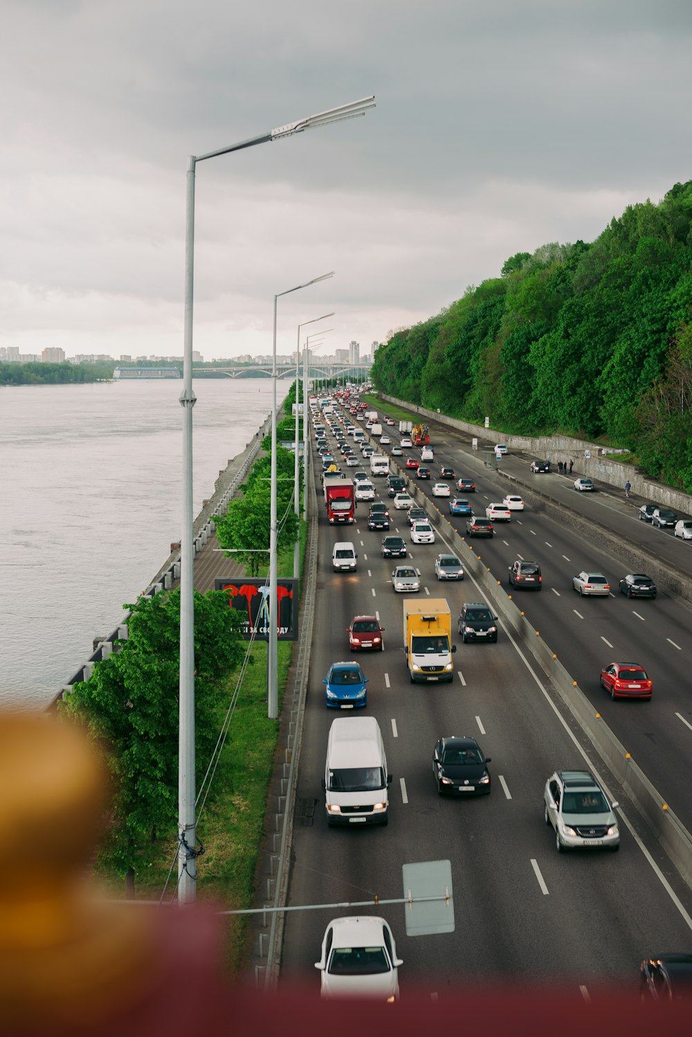 cars on road near body of water during daytime