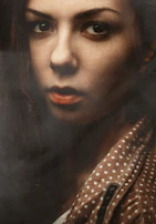 Luisa in a dramatic close-up, her expression reflecting deep emotion under soft studio lighting.