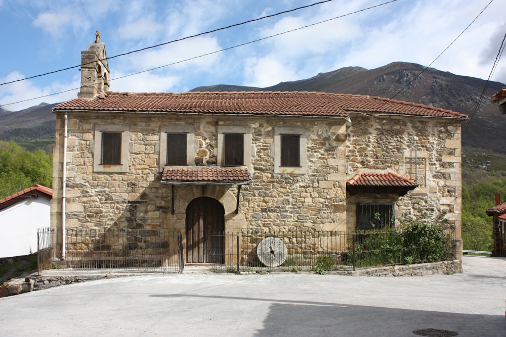 brown brick building near mountain under white clouds during daytime