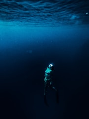 man in blue and white jacket and black pants in water