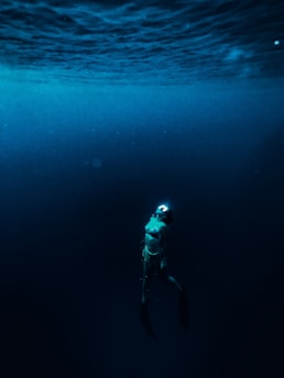 man in blue and white jacket and black pants in water