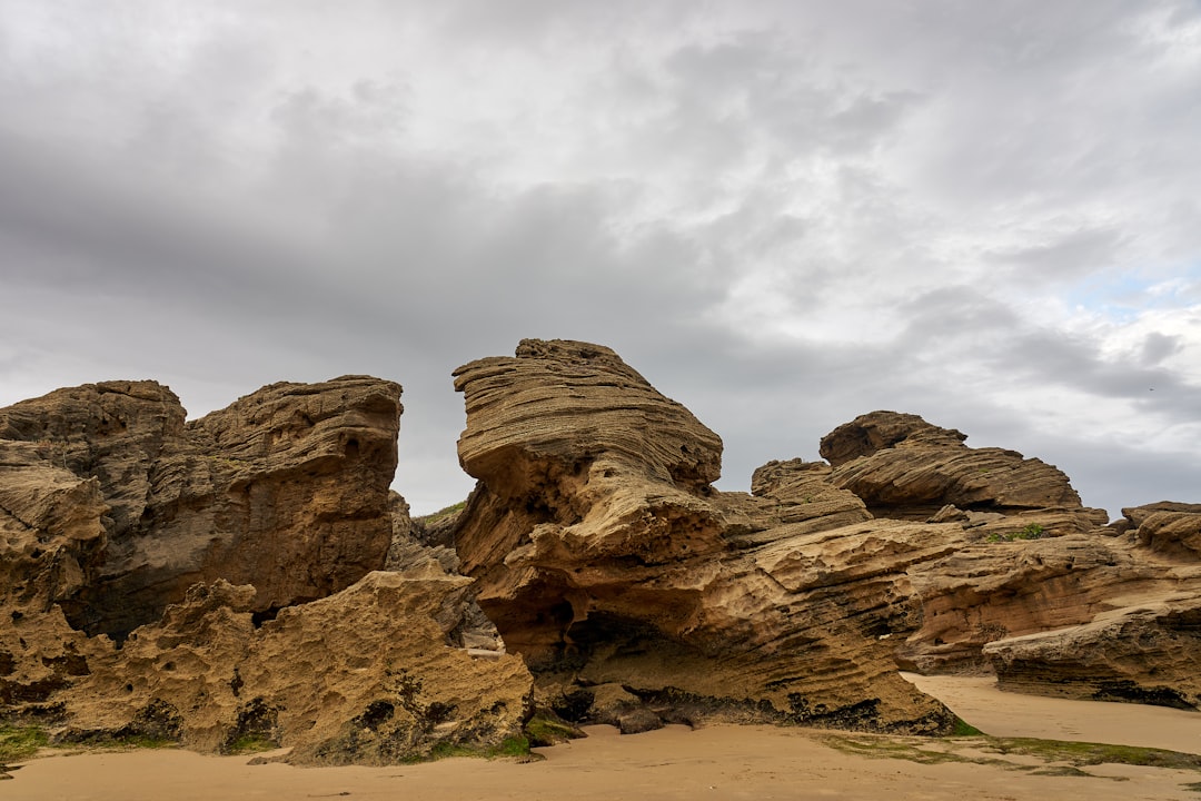 brown rock formation under white clouds during daytime