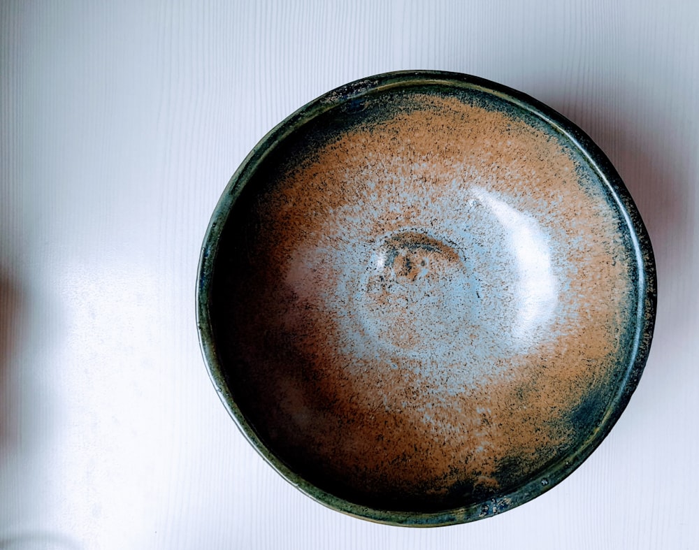 brown round plate on white textile