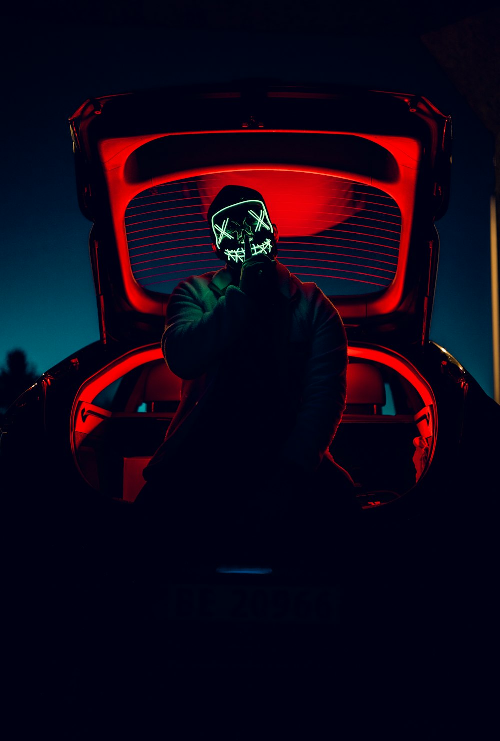 man in black jacket sitting on red car