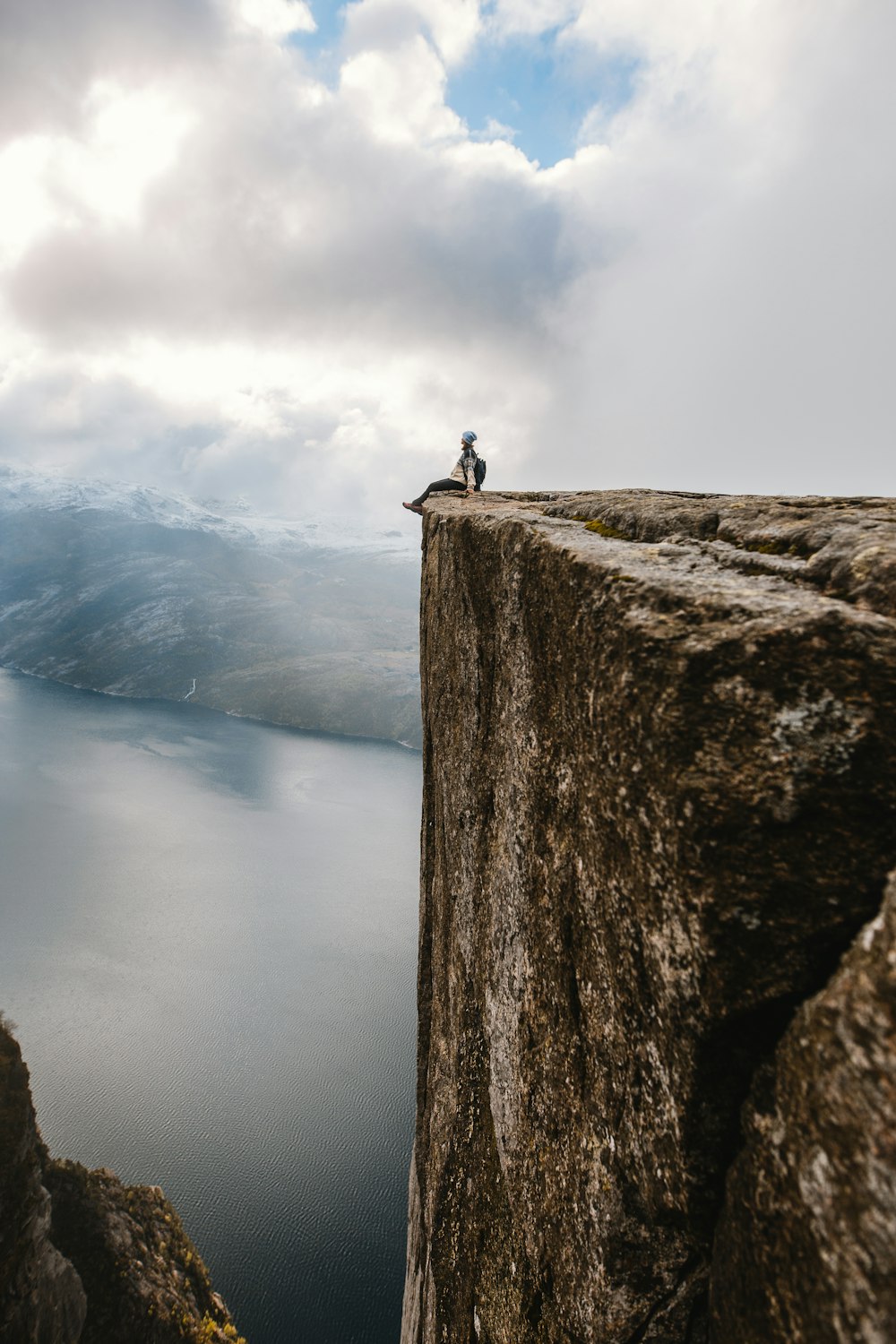 person standing on rock near body of water during daytime