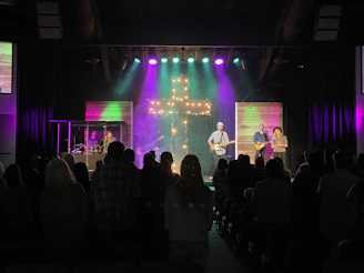 A vibrant church stage with colorful moving backgrounds illuminating the worship band.