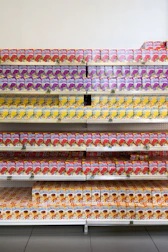 Stacks of neatly packed juice bottles ready for retail distribution in a bright warehouse.