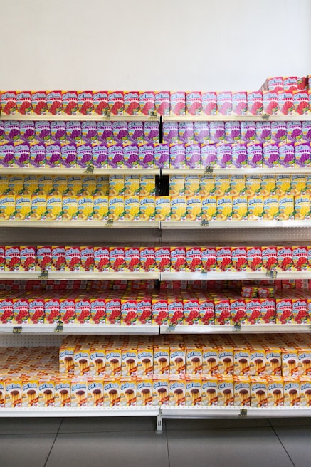 Close-up of colorful fruit juice bottles lined up on metal shelves, showcasing variety and freshness.