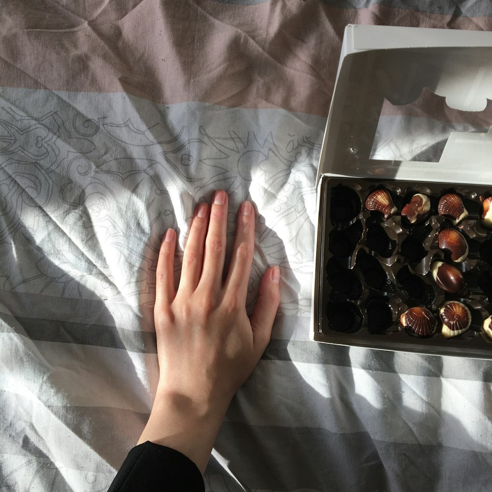 person holding white and brown box