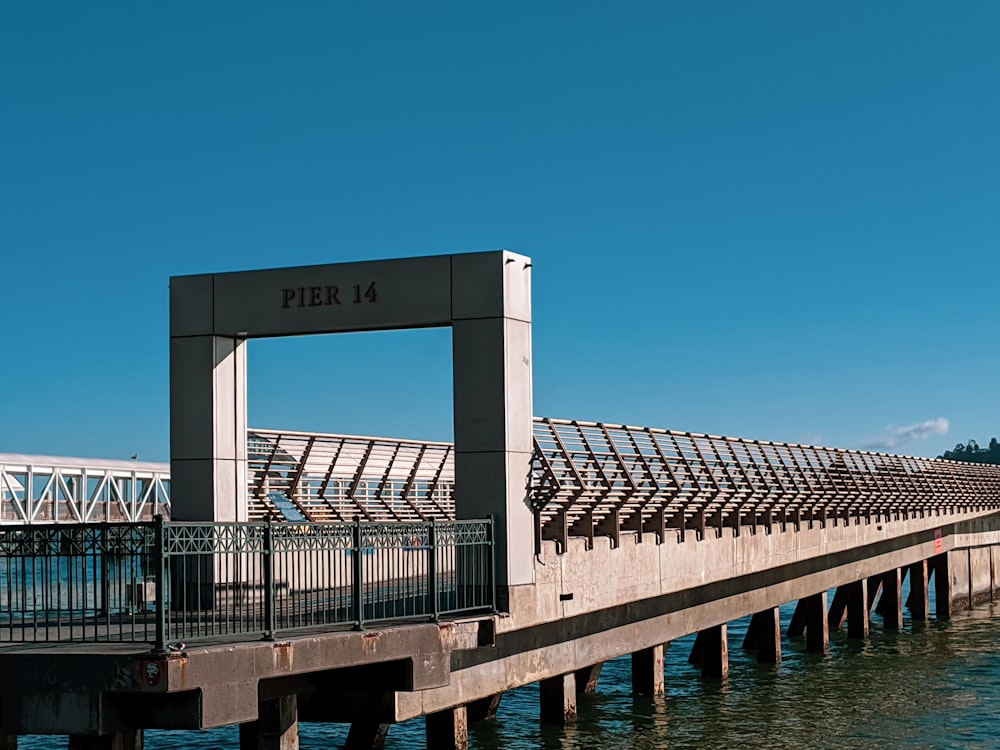 white and gray concrete bridge over body of water during daytime