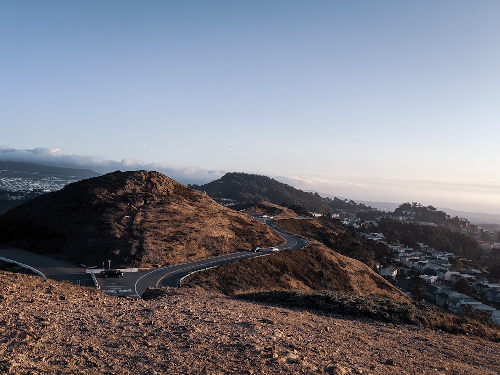 gray asphalt road on brown mountain during daytime