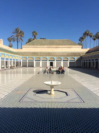 A serene courtyard with geometric Islamic patterns and students engaging in group study.