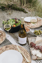 Ultralight aluminum folding table set up on a beach with a family enjoying a picnic.