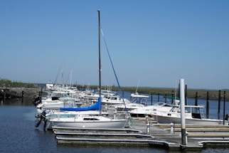 A serene marina with boats docked and clear blue water.