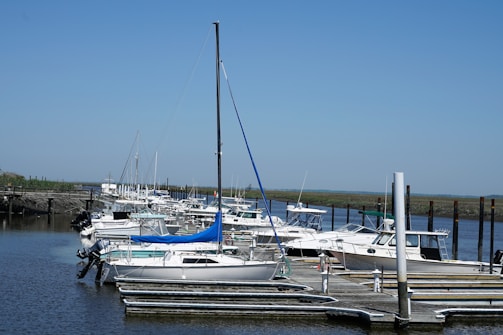 A serene marina with boats docked and clear blue water.