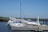 A serene marina scene with a well-maintained boat docked under clear blue skies.