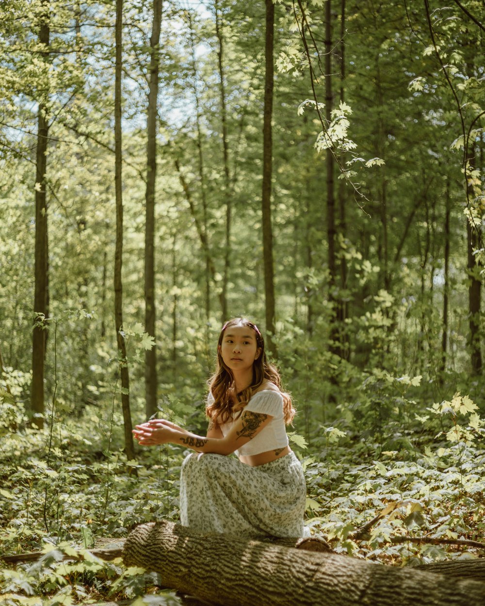 woman in white dress standing on forest during daytime