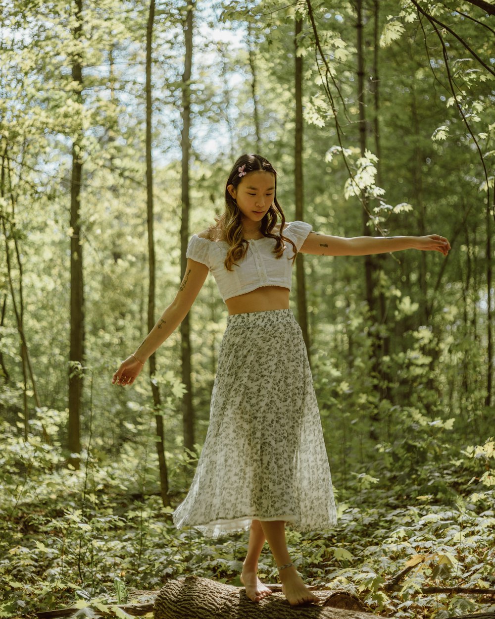 Woman in white crop top and black and white floral skirt standing on forest  during daytime photo – Free Apparel Image on Unsplash