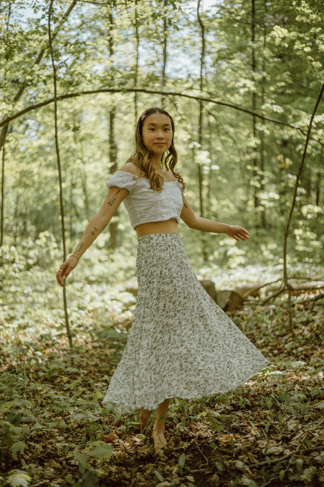 woman in white dress standing on forest during daytime