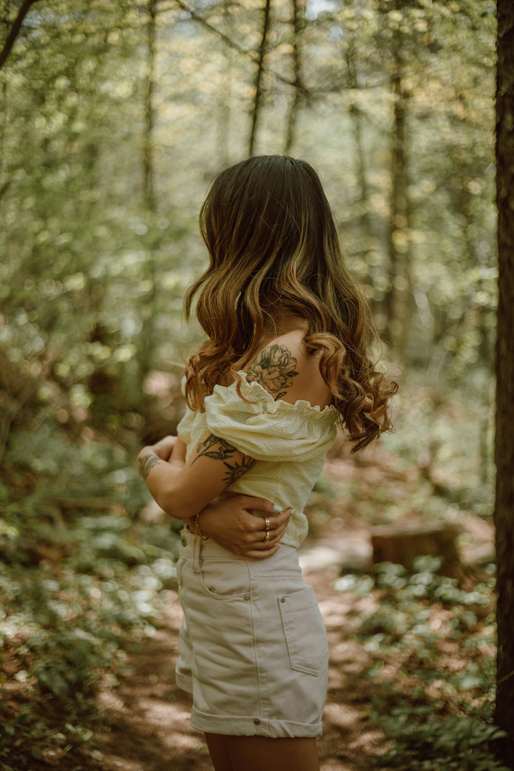 girl in white dress standing on forest during daytime