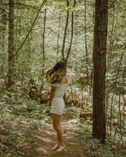 A woman standing barefoot in nature, embracing freedom and wildness.