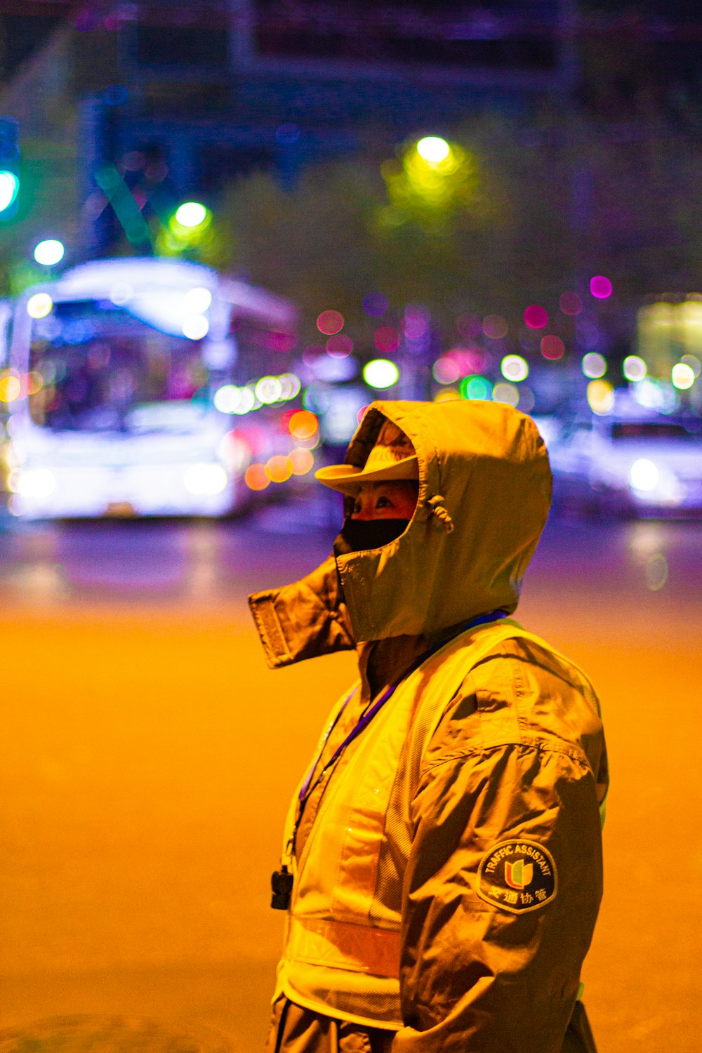 person in yellow hoodie standing on street during night time