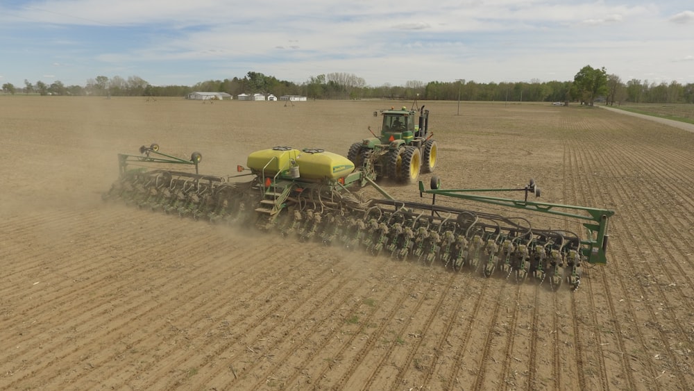 green and yellow heavy equipment on field during daytime