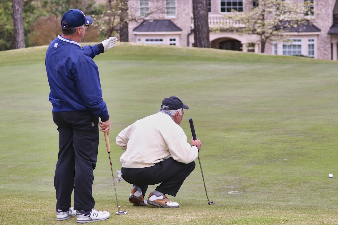 Deux golfeurs analysant la ligne de jeu, carte de score en main