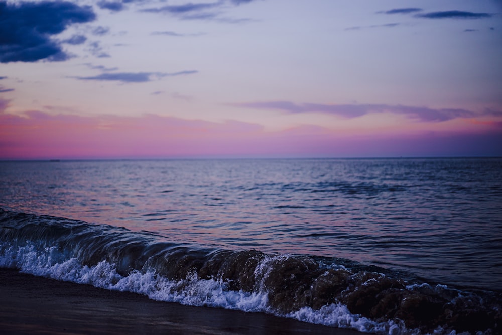 onde dell'oceano sotto il cielo blu durante il giorno