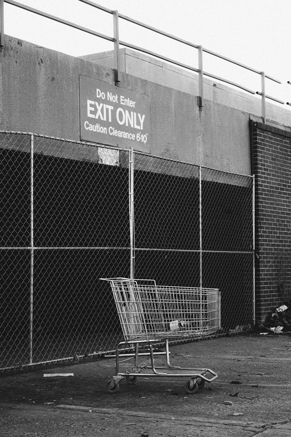 grayscale photo of shopping cart near building