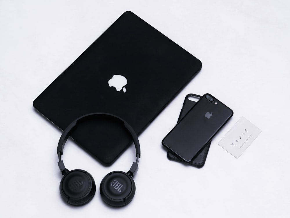 black and silver headphones beside black ipad