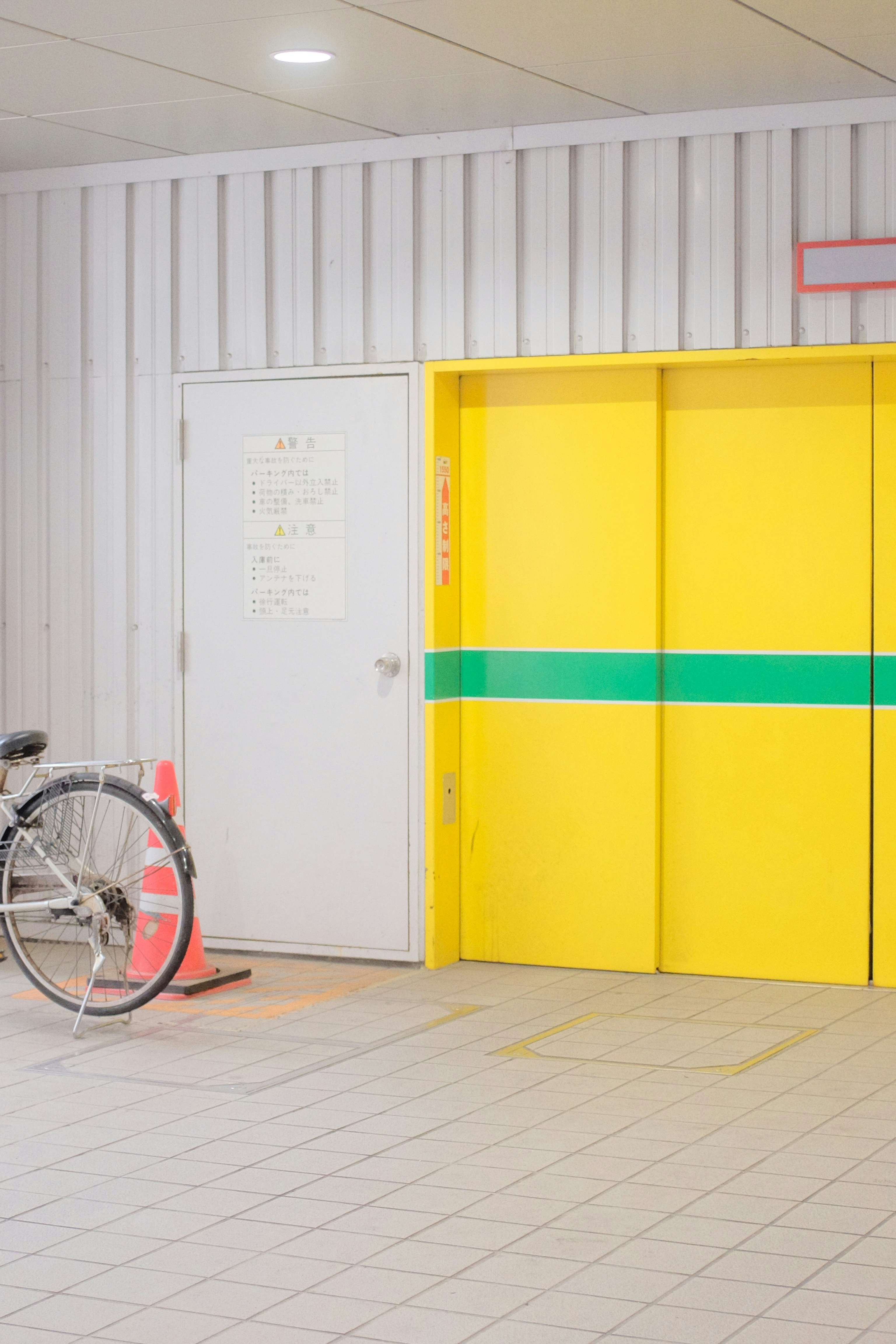 black bicycle parked beside white and yellow wall