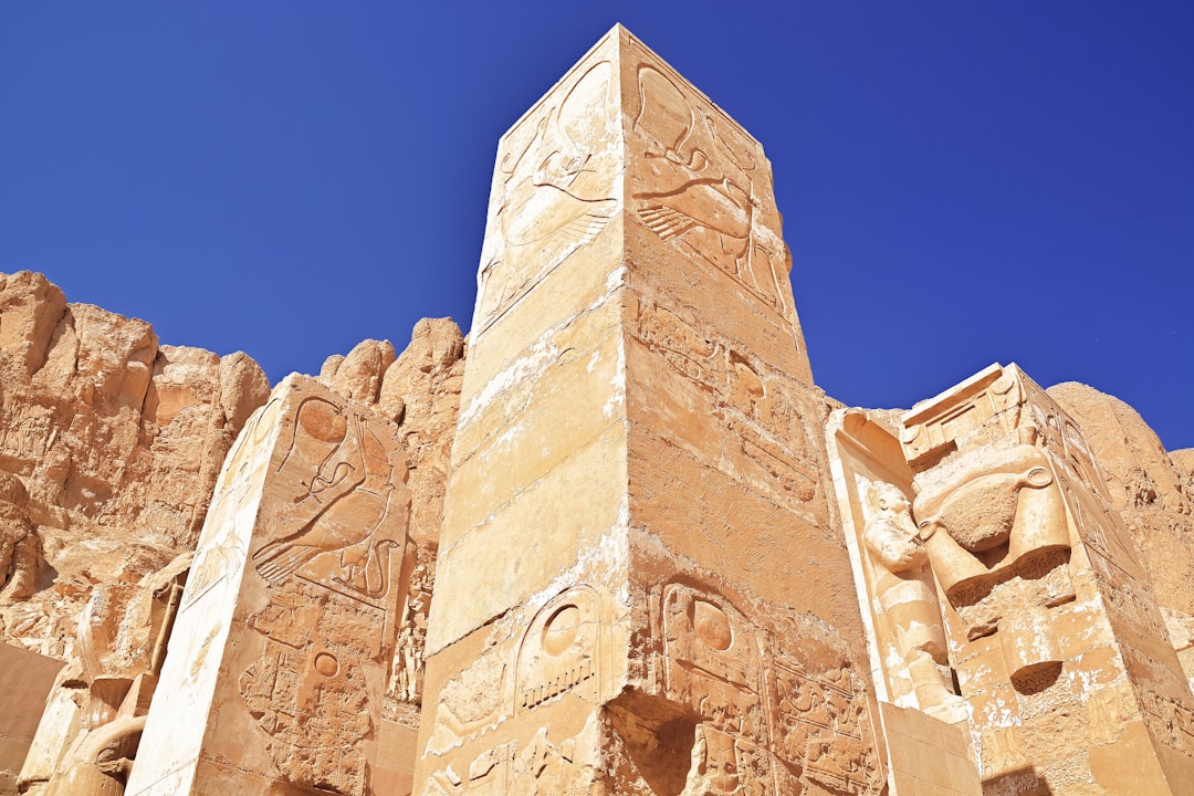 low angle photography of beige concrete building under blue sky during daytime