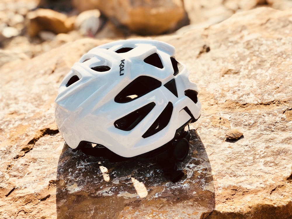 white and black plastic ball on brown and black stone