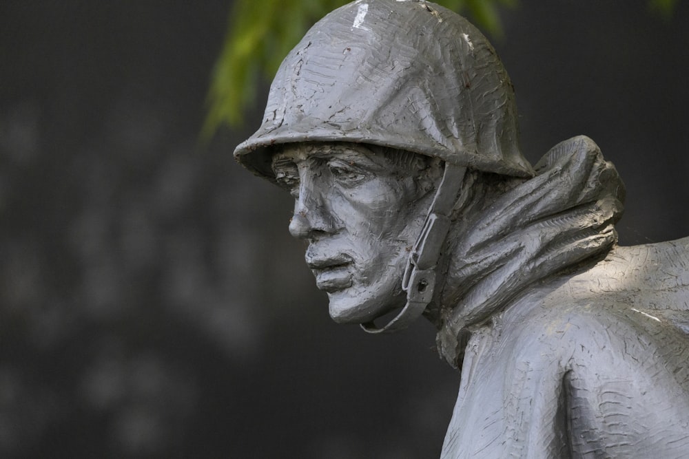 man in hat statue in grayscale photography