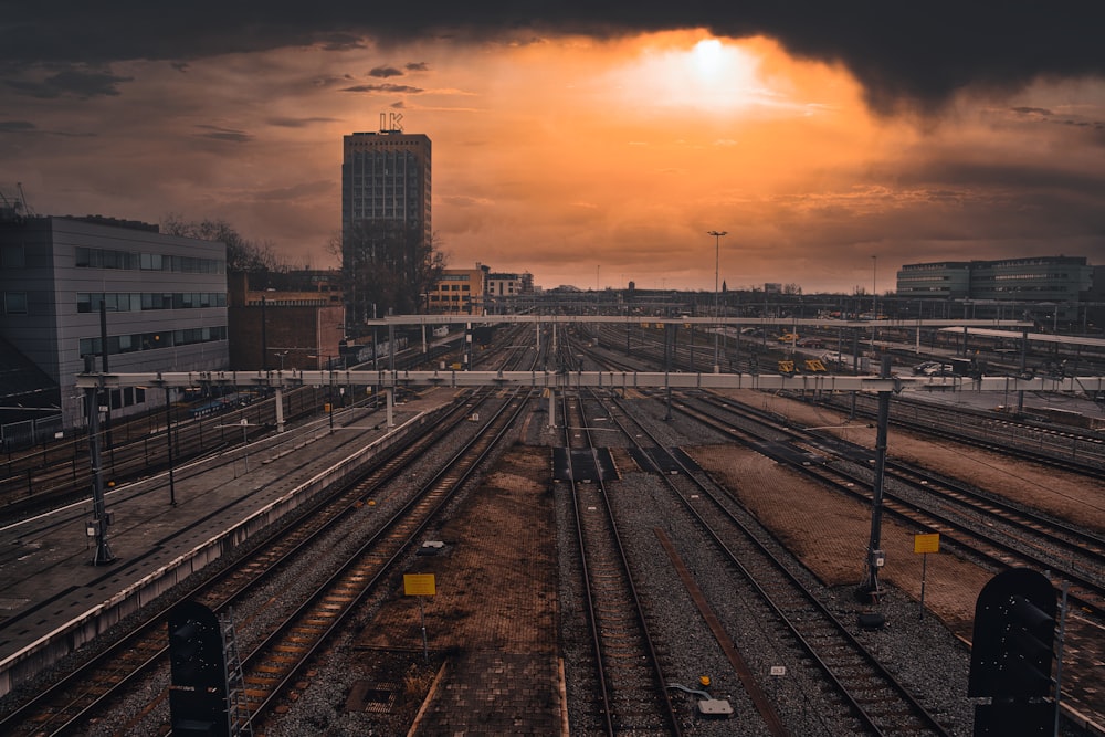 train rail near city buildings during sunset