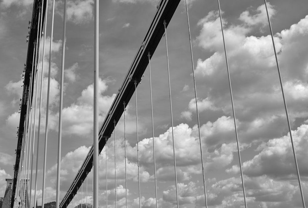 grayscale photo of bridge under cloudy sky