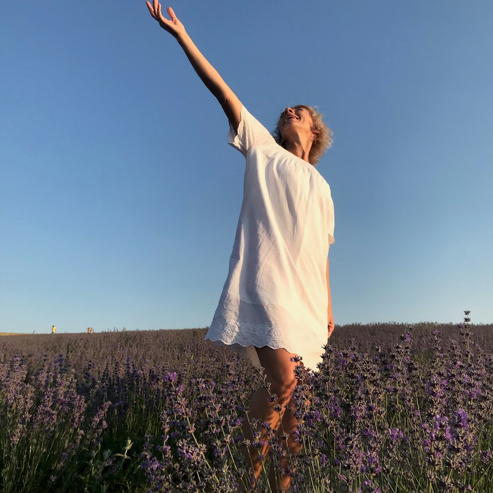 woman in white shirt standing on purple flower field during daytime