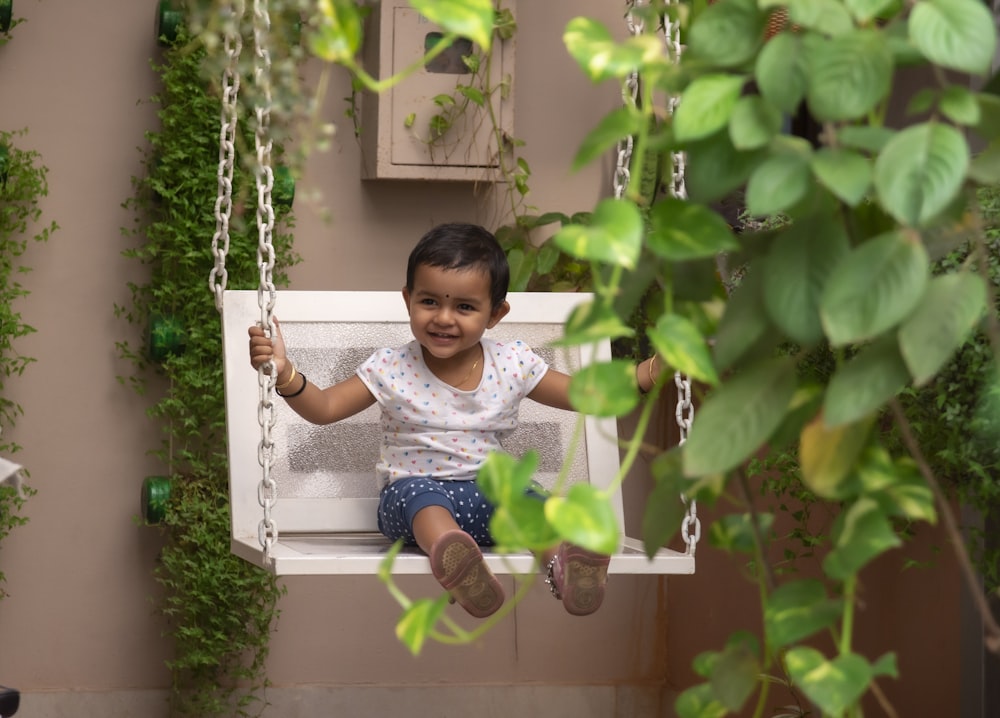 girl in blue and white stripe shirt sitting on swing