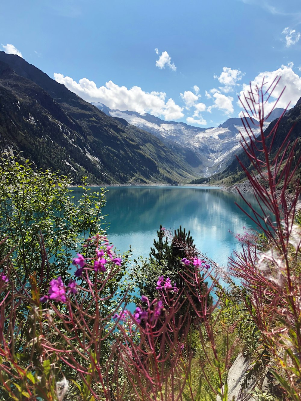 lake surrounded by mountains under blue sky during daytime