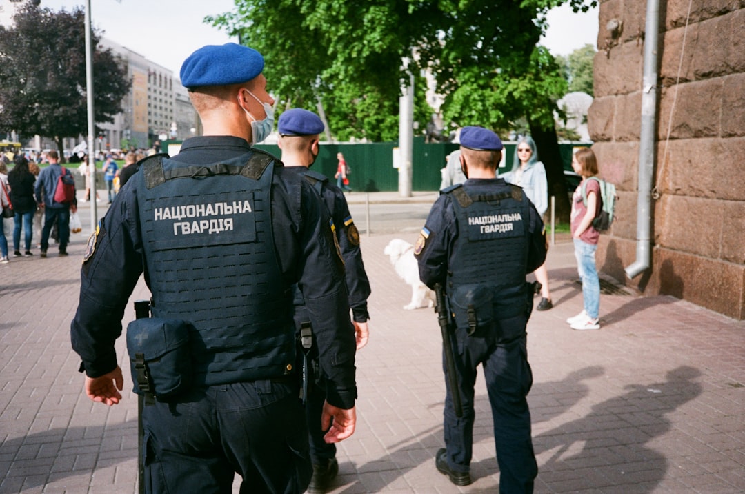 2 men in police uniform standing on sidewalk during daytime