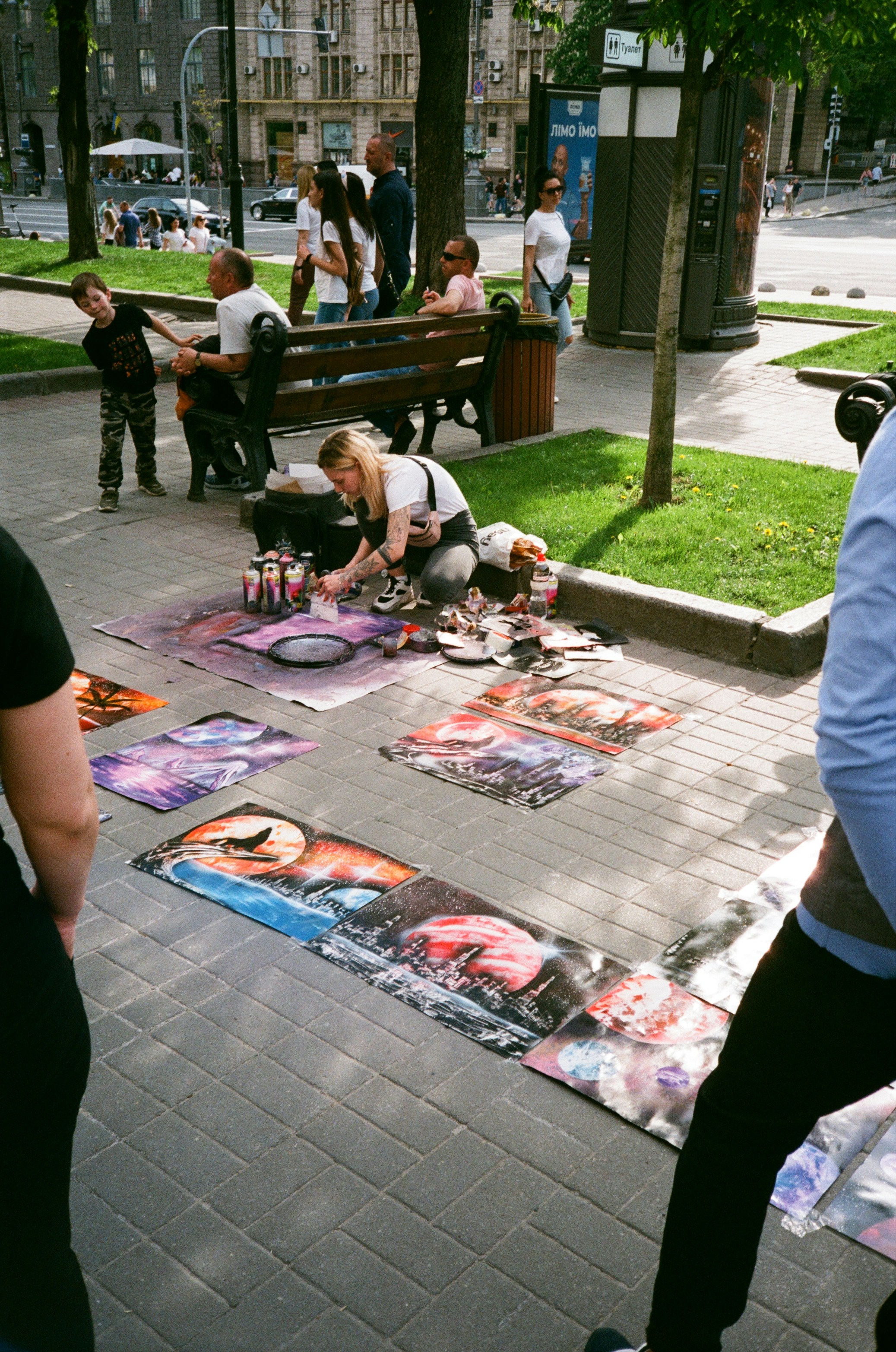 Watercolor painting of people gathered around a table, painting and decorating oyster shells, laughing and interacting.